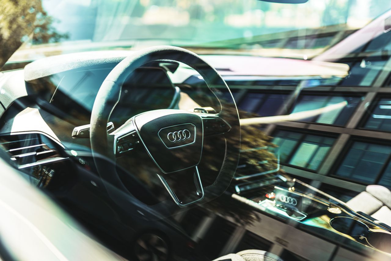 Close-up of an Audi car's interior focusing on the steering wheel, showcasing luxury design.