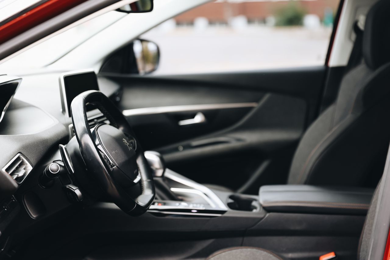 Sleek and modern car interior featuring steering wheel and dashboard in focus.